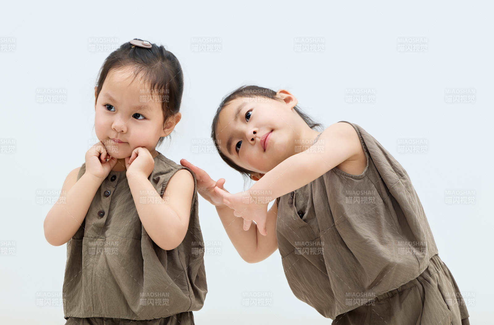 白色背景下頑皮可愛的雙胞胎小女孩