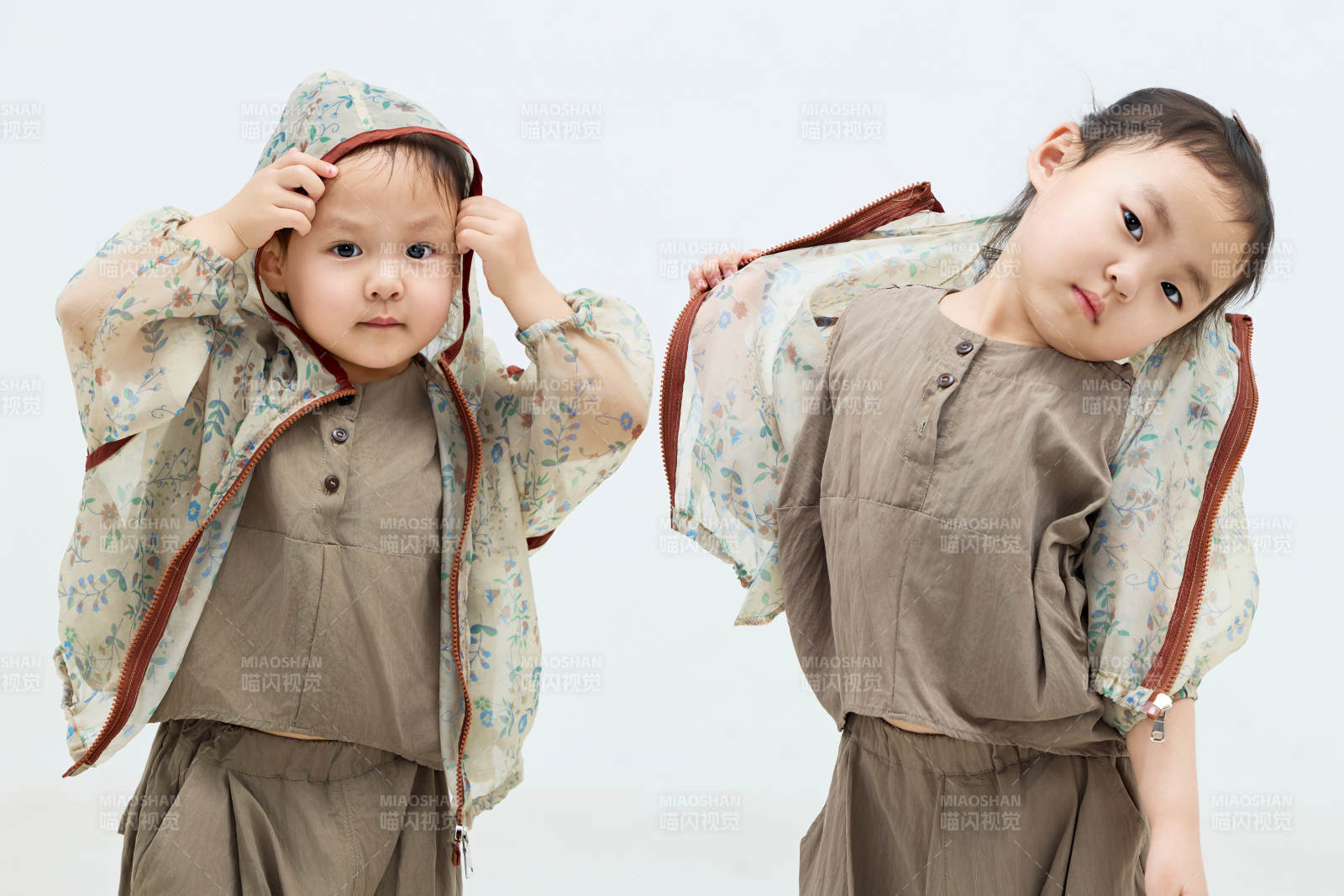 白色背景下顽皮可爱的双胞胎小女孩