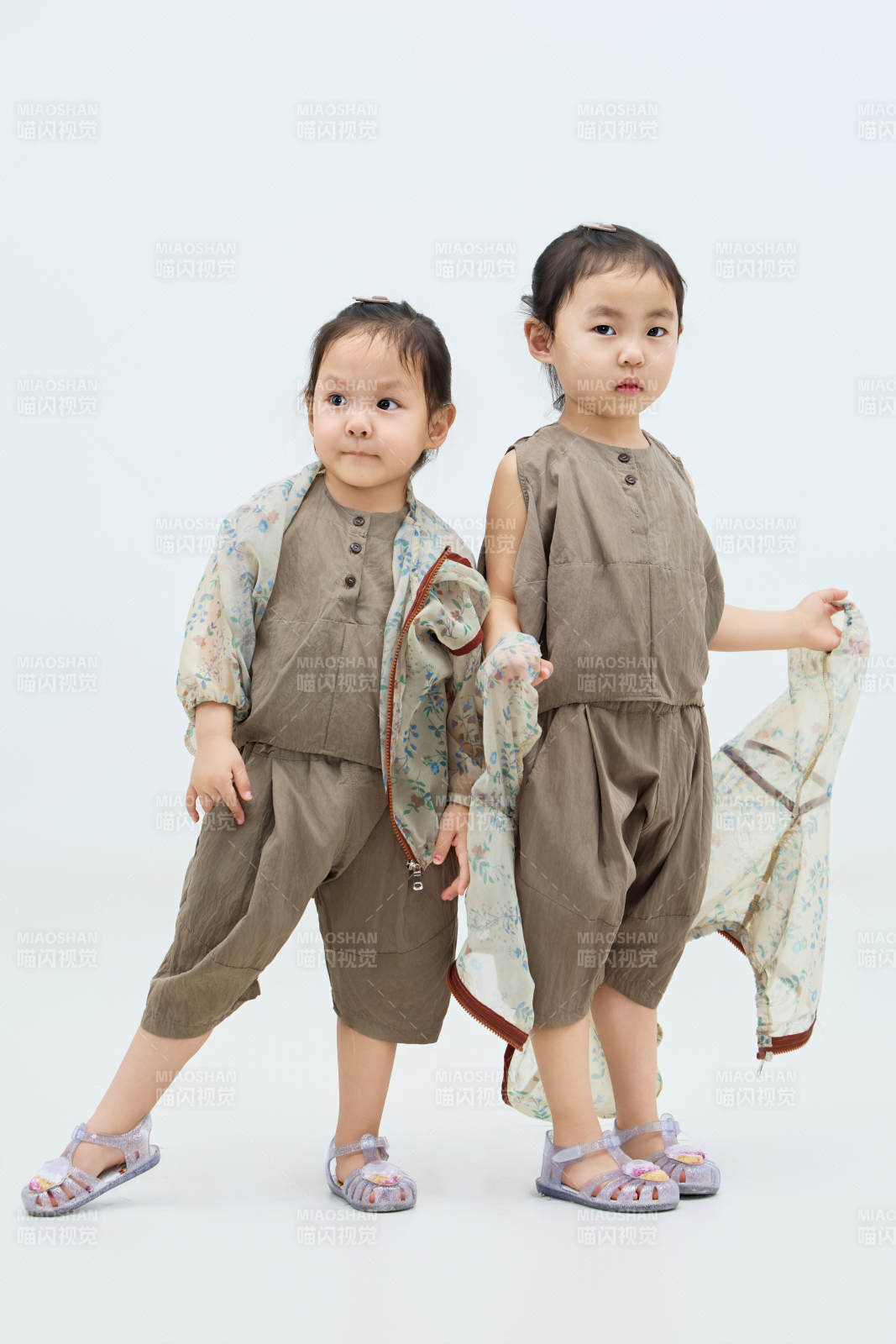 白色背景下頑皮可愛(ài)的雙胞胎小女孩