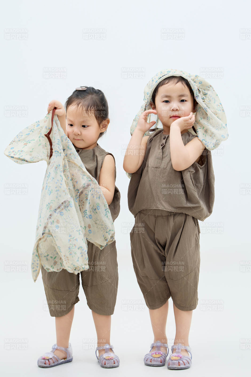 白色背景下顽皮可爱的双胞胎小女孩