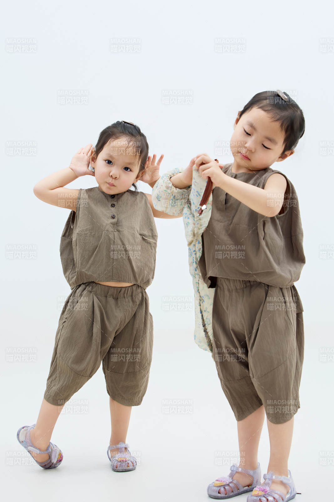 白色背景下頑皮可愛(ài)的雙胞胎小女孩
