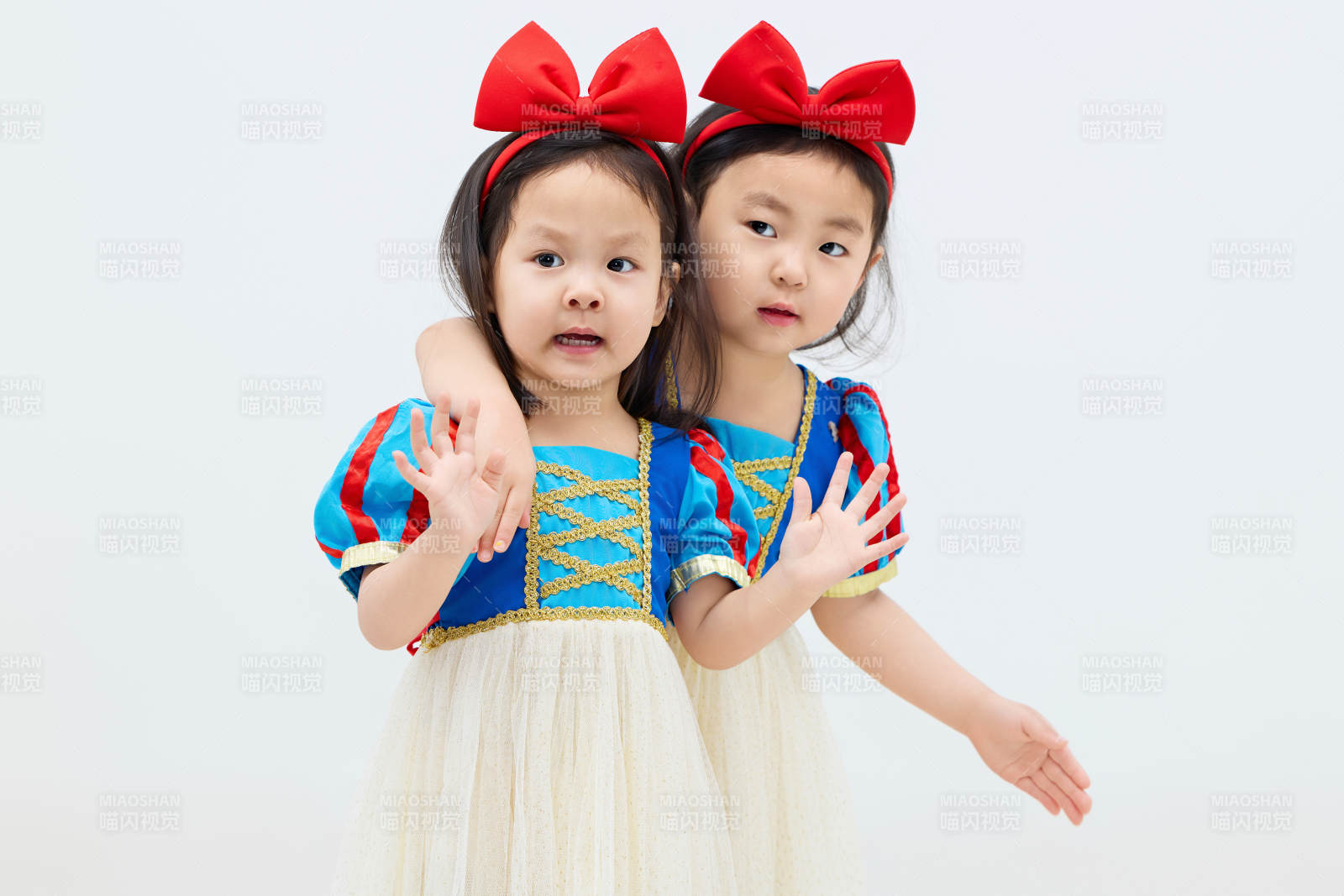 白色背景下頑皮可愛的雙胞胎小女孩