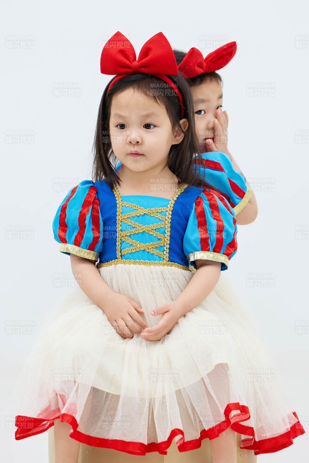 白色背景下頑皮可愛的雙胞胎小女孩