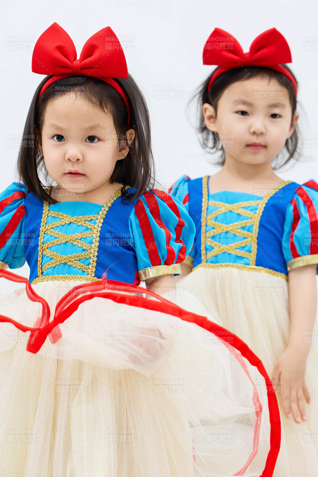 白色背景下頑皮可愛的雙胞胎小女孩