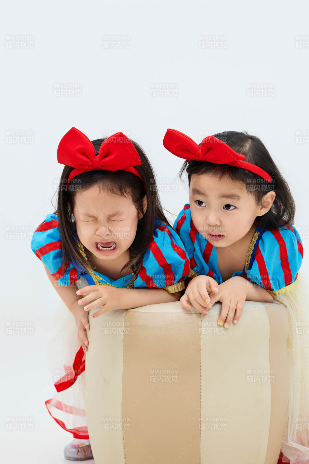 白色背景下頑皮可愛的雙胞胎小女孩