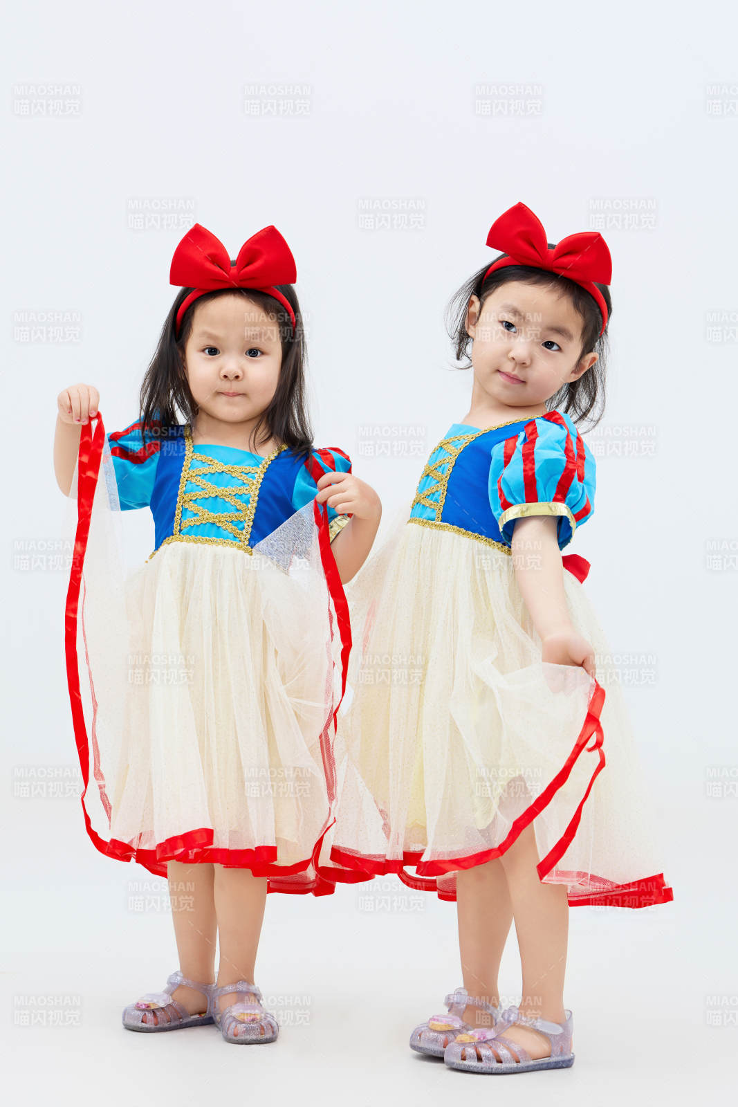 白色背景下頑皮可愛的雙胞胎小女孩