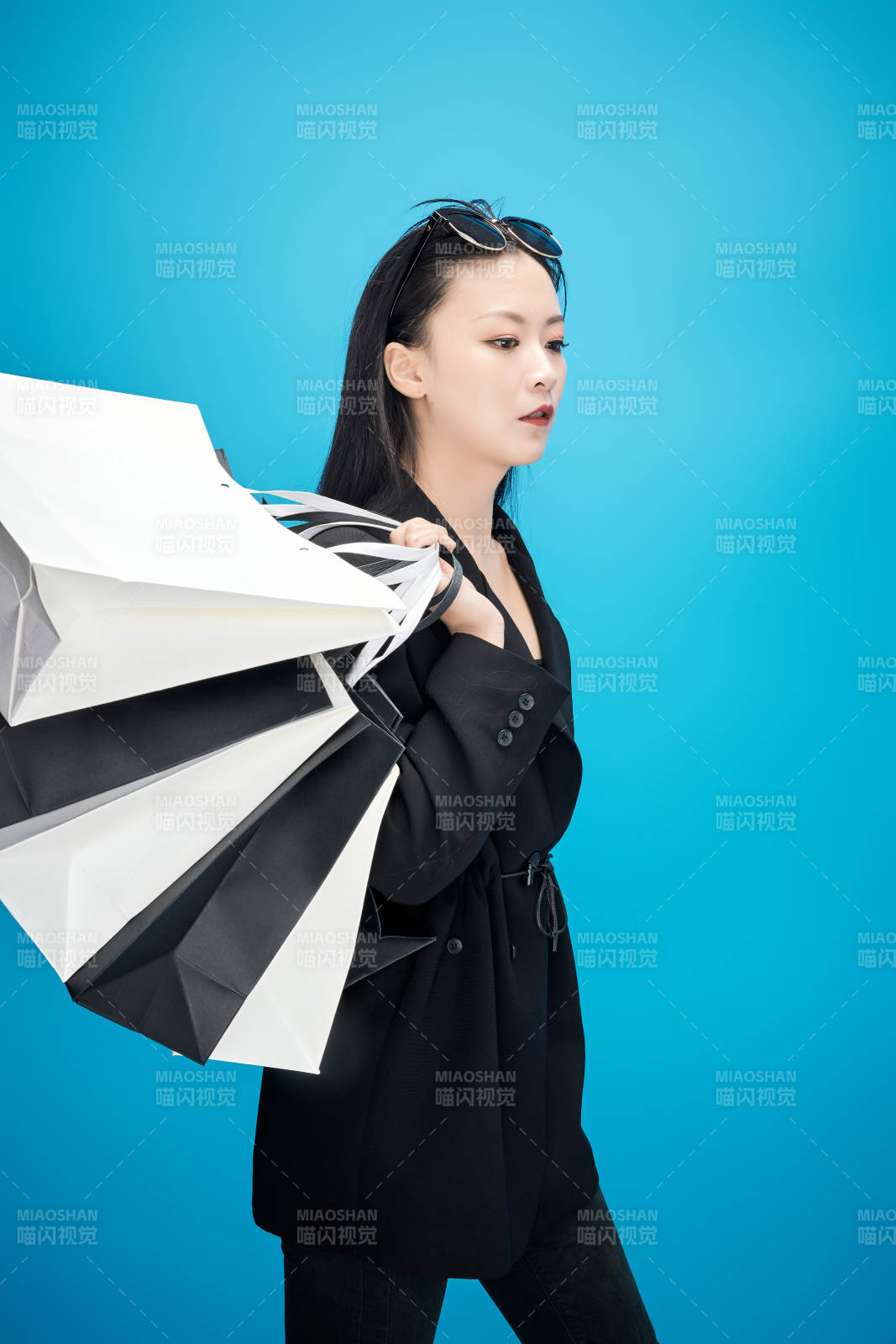 青藍色背景下手提購物袋的亞洲時尚少女