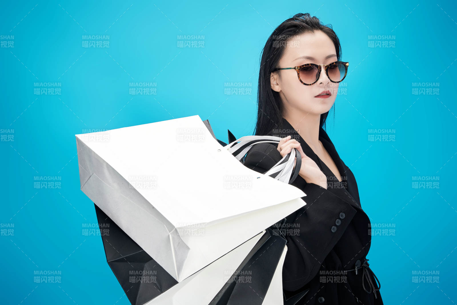 青藍(lán)色背景下手提購物袋的亞洲時(shí)尚少女