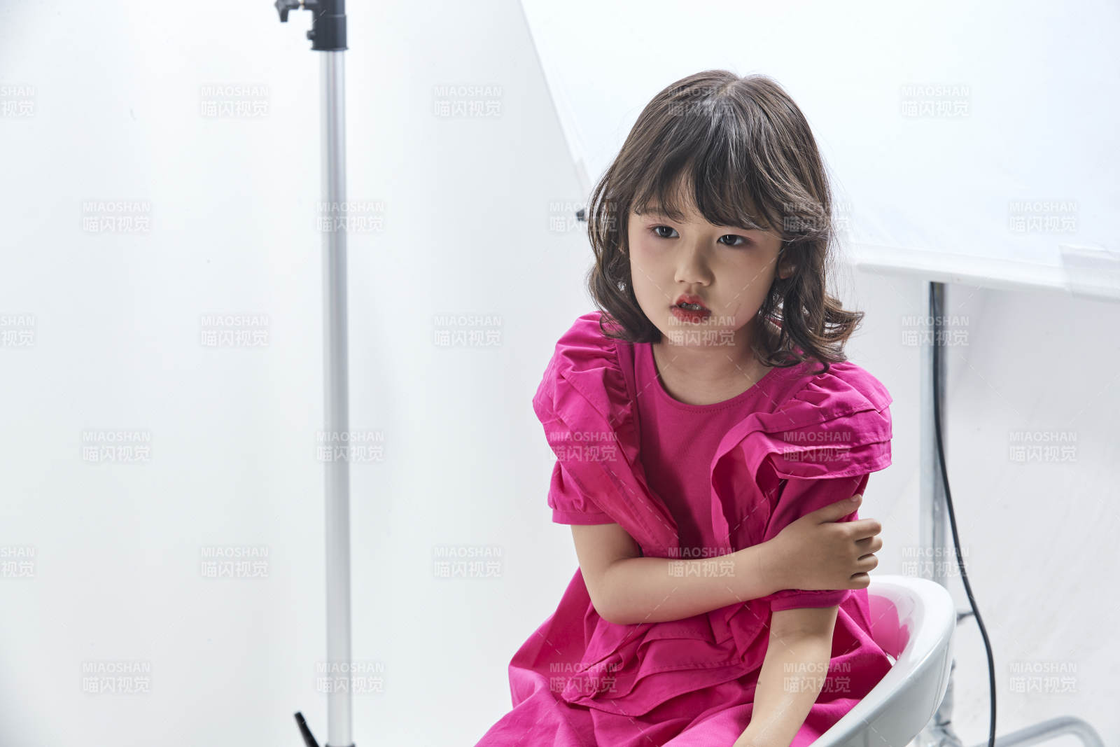 白色背景里坐在凳子上的可爱的亚洲小女孩儿童