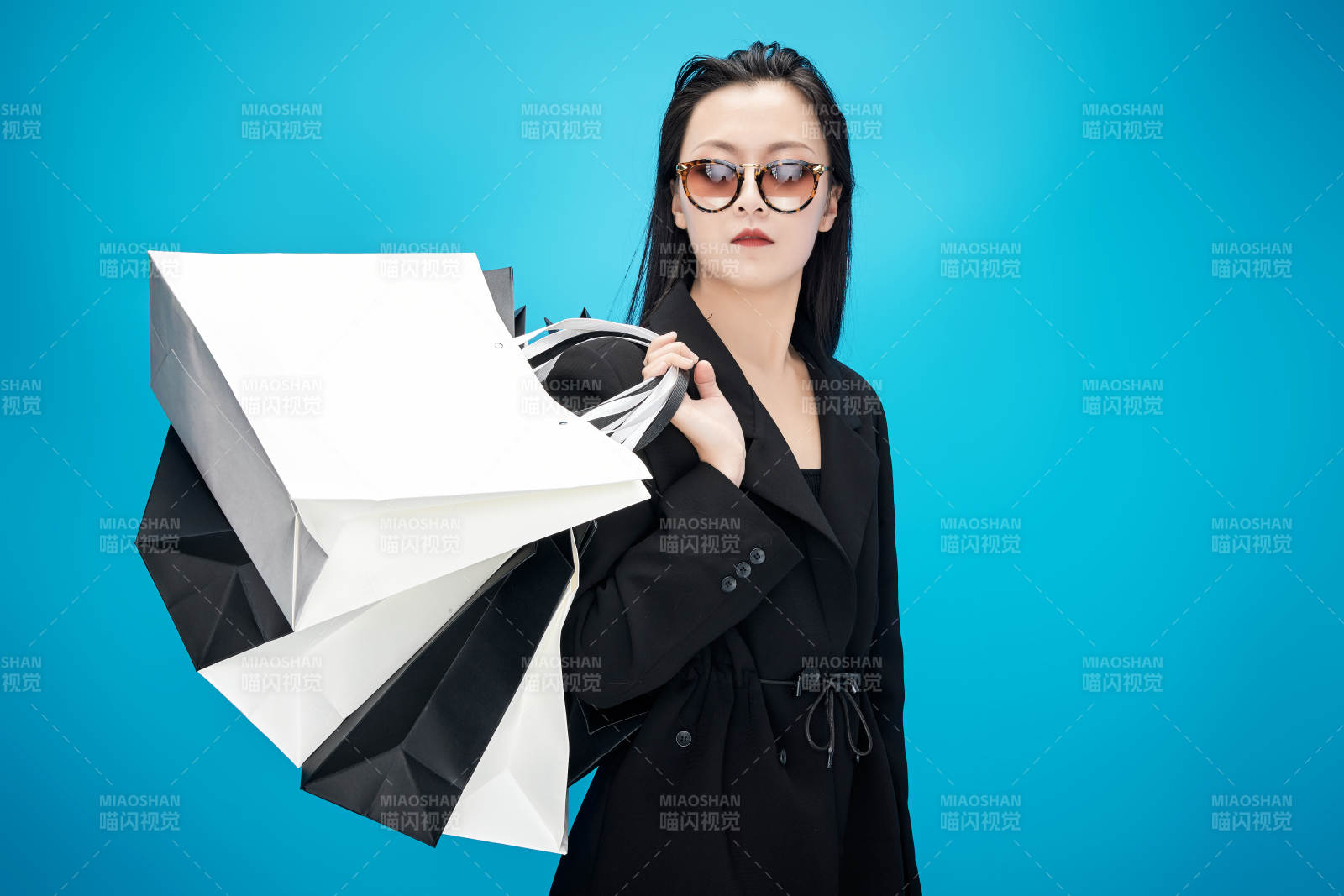 青藍(lán)色背景下手提購(gòu)物袋的亞洲時(shí)尚少女