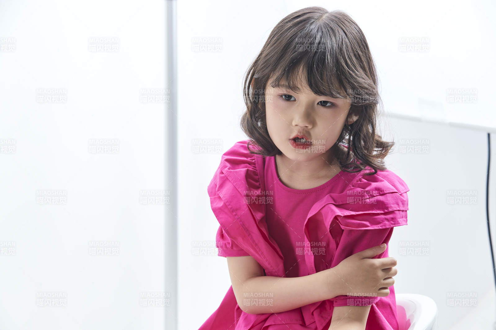 白色背景里坐在凳子上的可愛的亞洲小女孩兒童