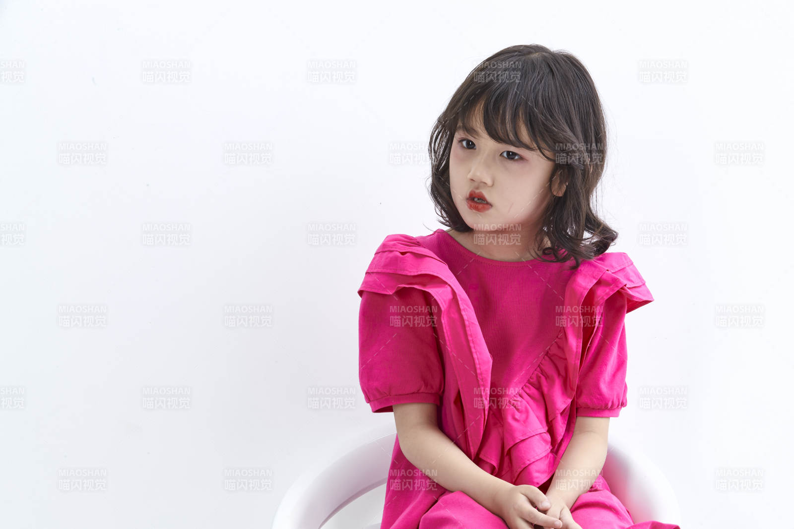 白色背景里坐在凳子上的可愛的亞洲小女孩兒童