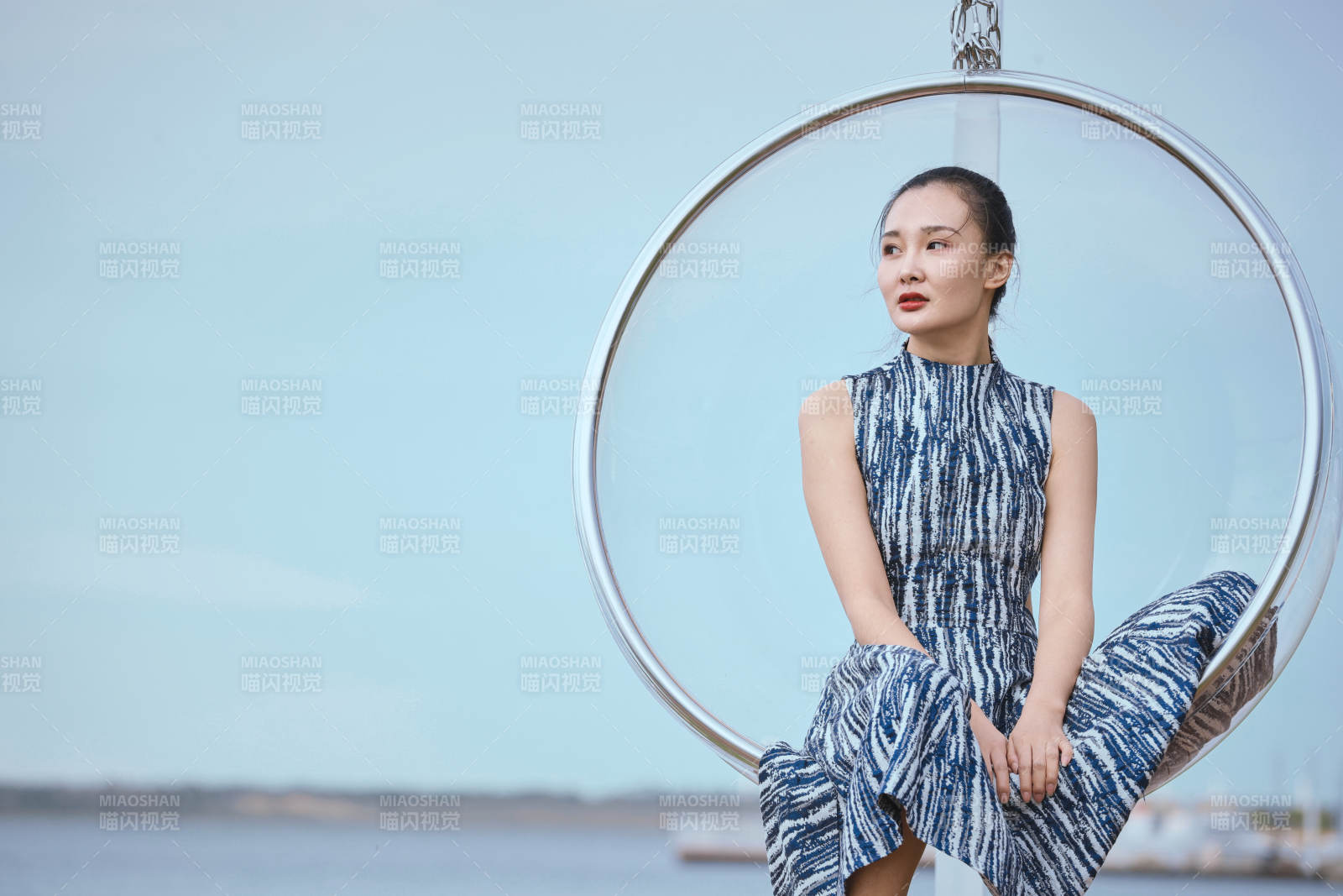 草原湖畔坐在透明秋千里的亞洲年輕女性人像