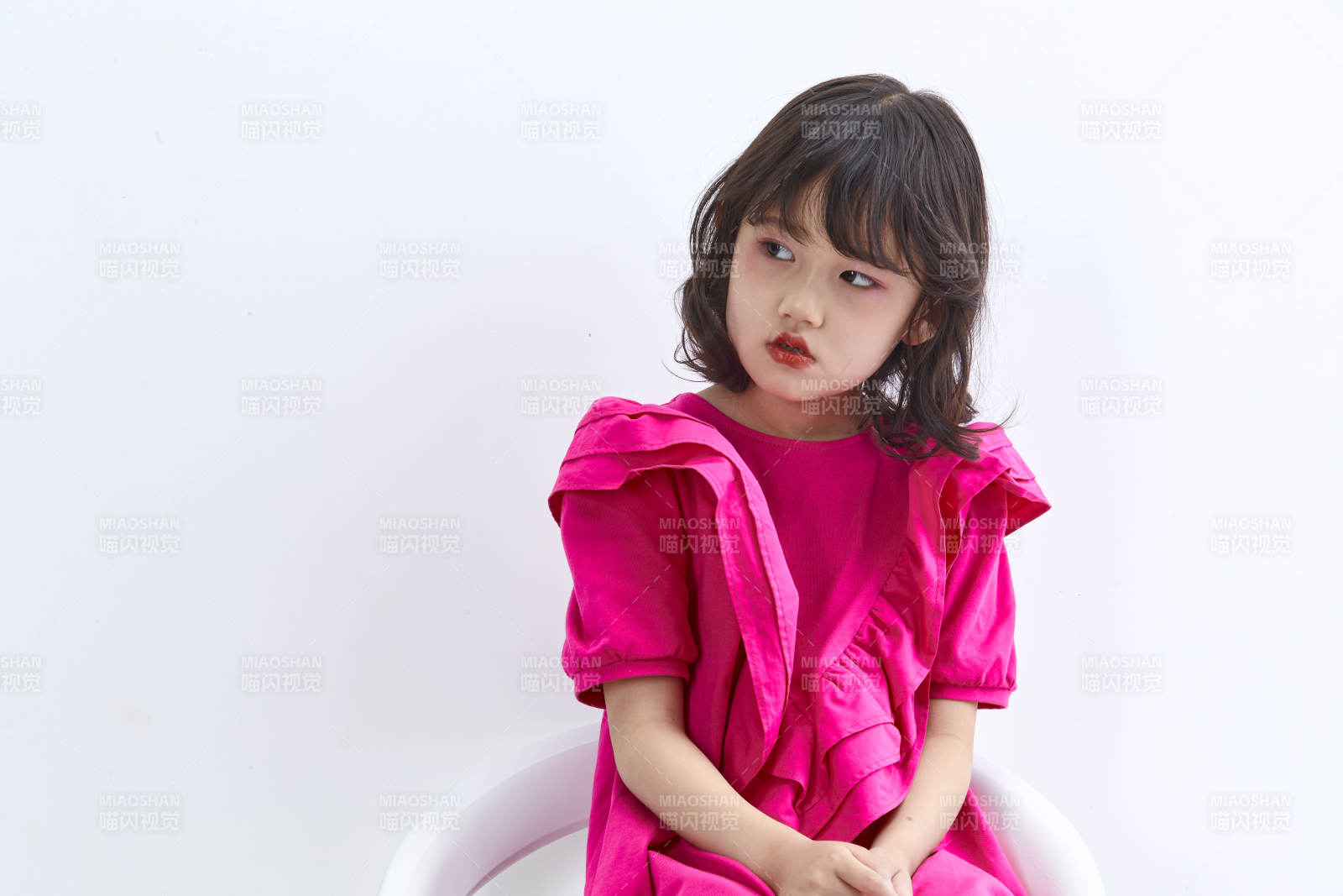 白色背景里坐在凳子上的可愛的亞洲小女孩兒童