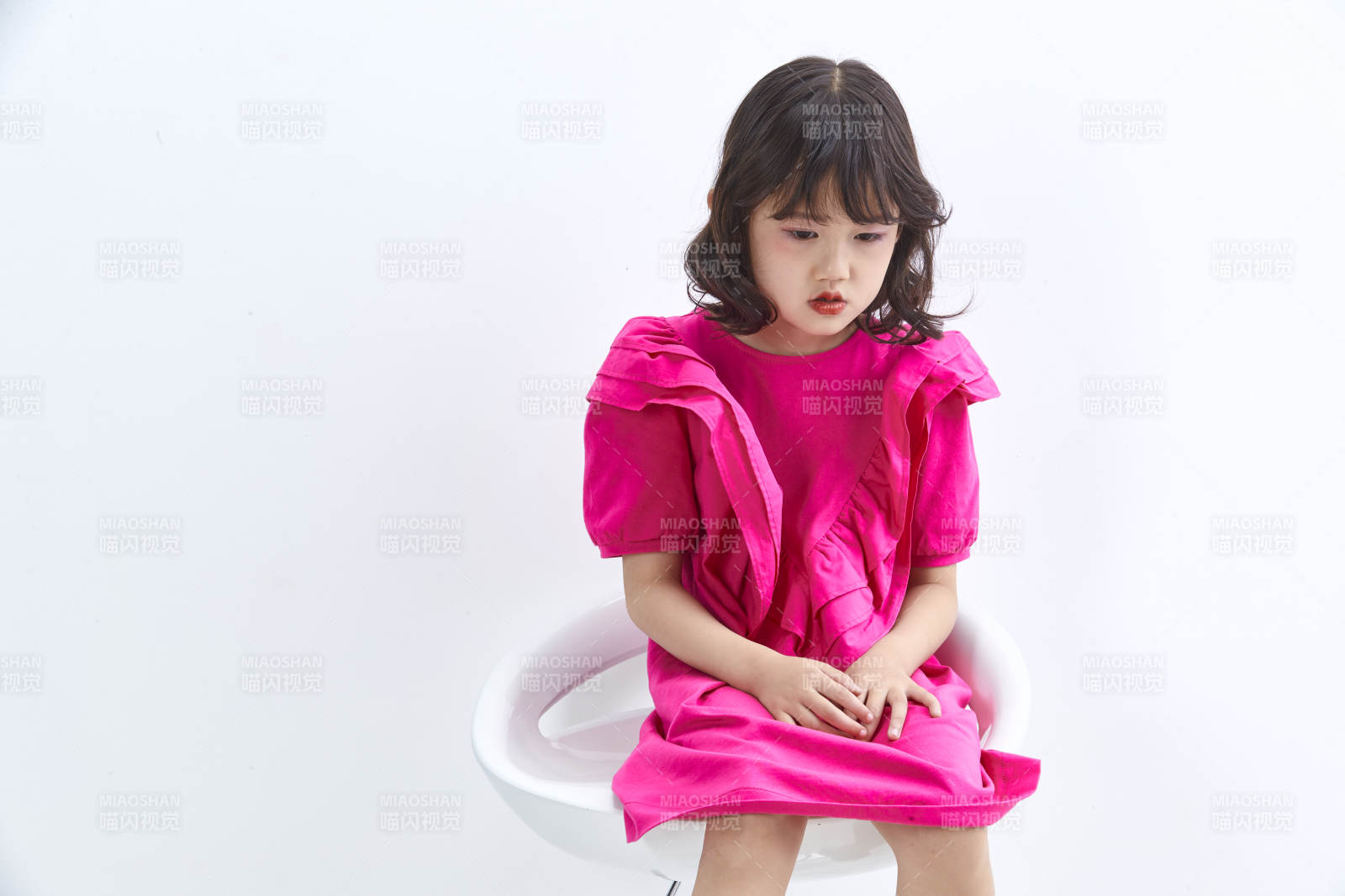 白色背景里坐在凳子上的可愛的亞洲小女孩兒童