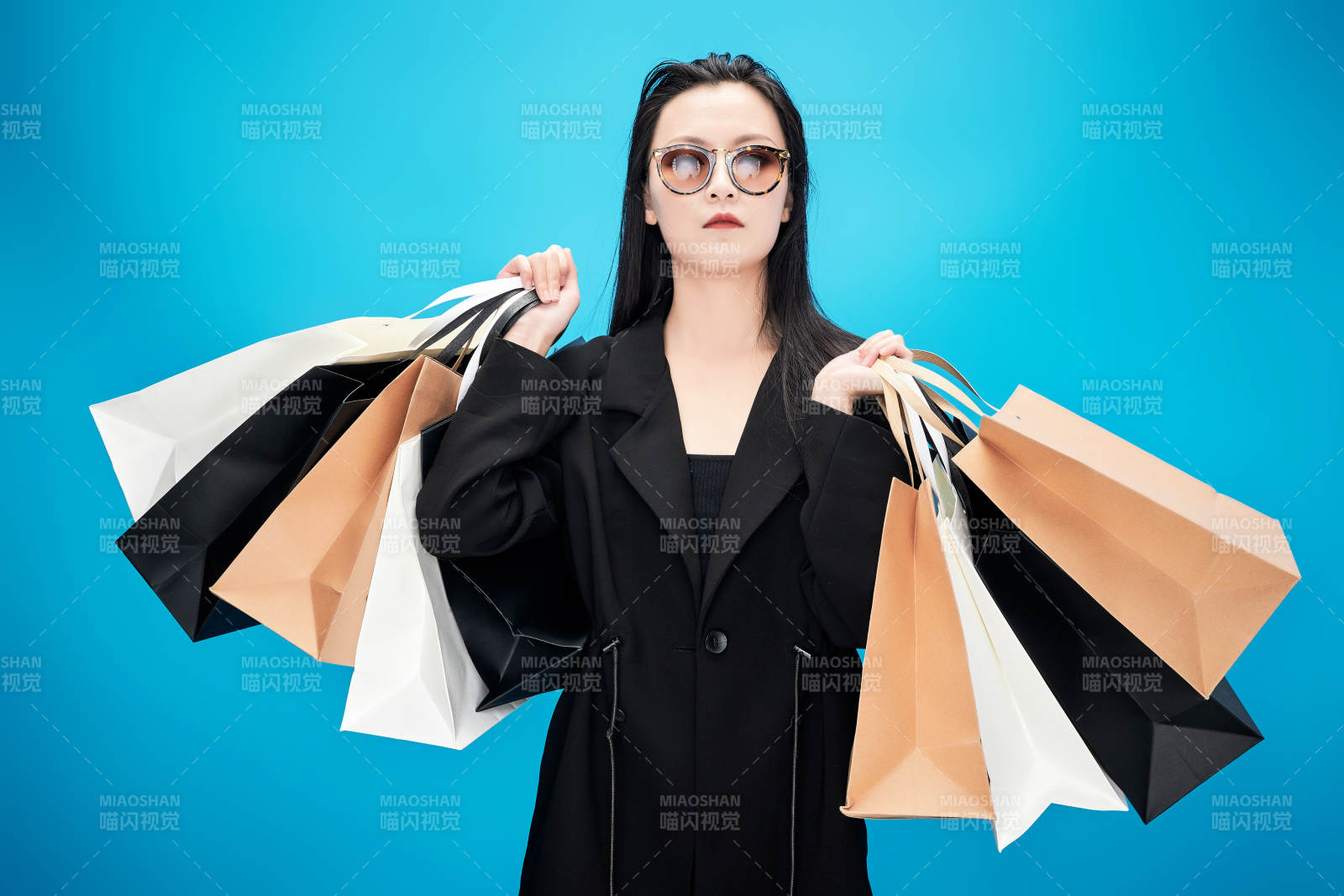 青藍色背景下手提購物袋的亞洲時尚少女