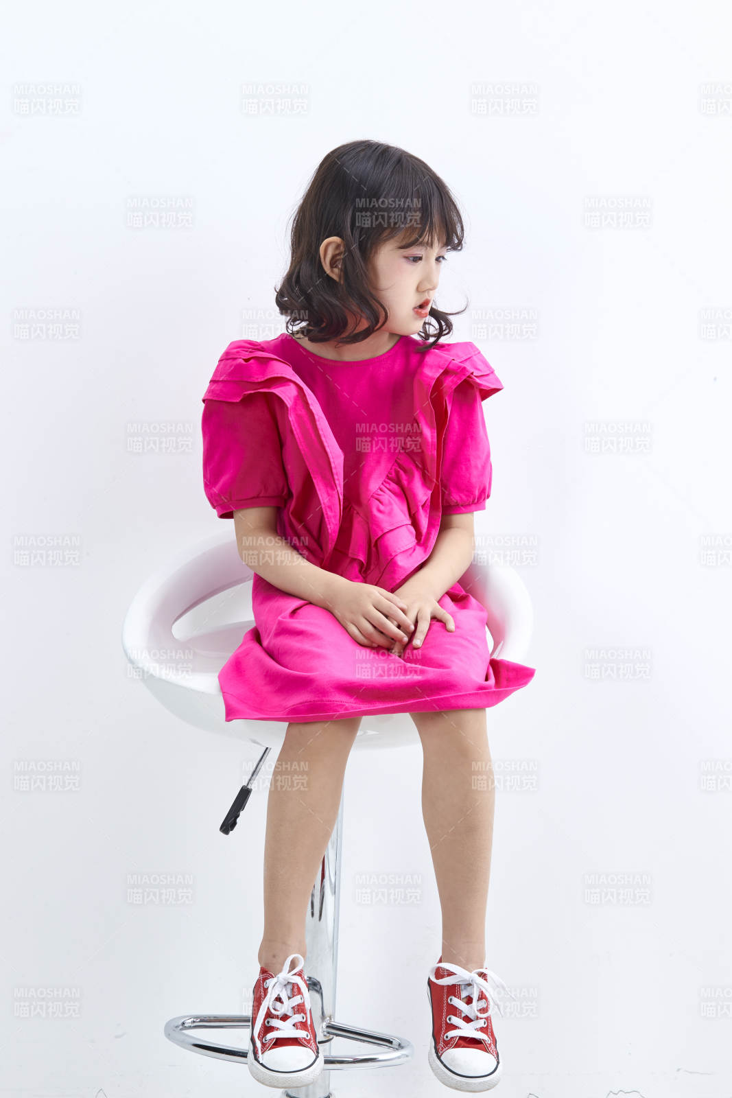 白色背景里坐在凳子上的可愛的亞洲小女孩兒童