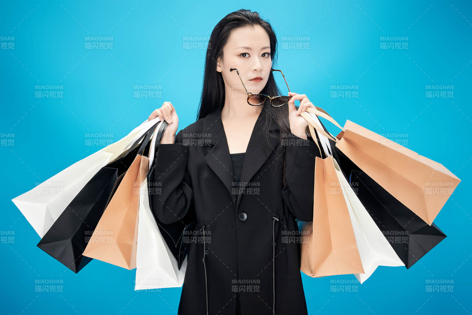 青藍色背景下手提購物袋的亞洲時尚少女