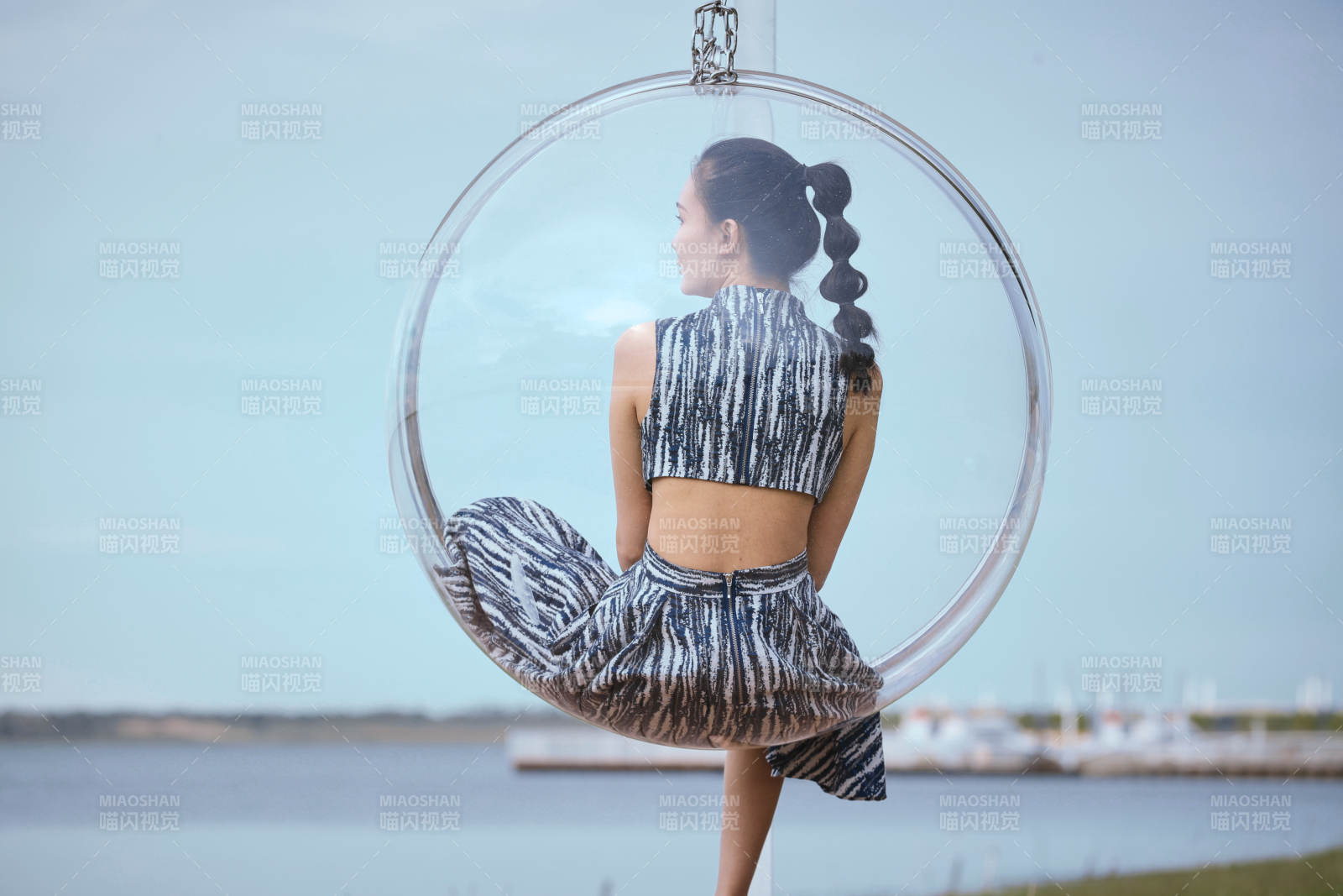 草原湖畔坐在透明秋千里的亞洲年輕女性人像