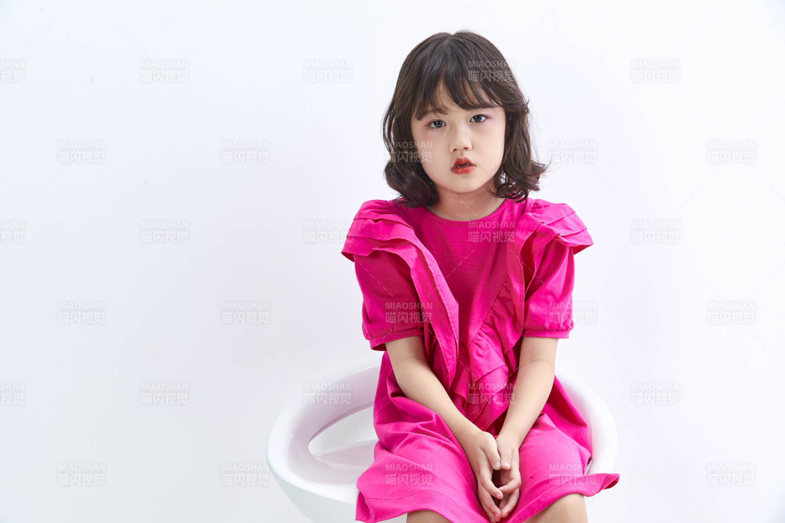 白色背景里坐在凳子上的可愛的亞洲小女孩兒童