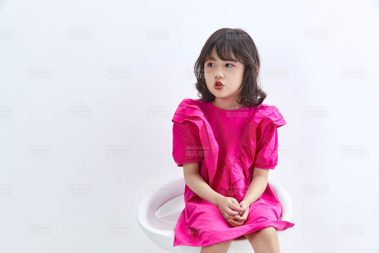 白色背景里坐在凳子上的可愛的亞洲小女孩兒童