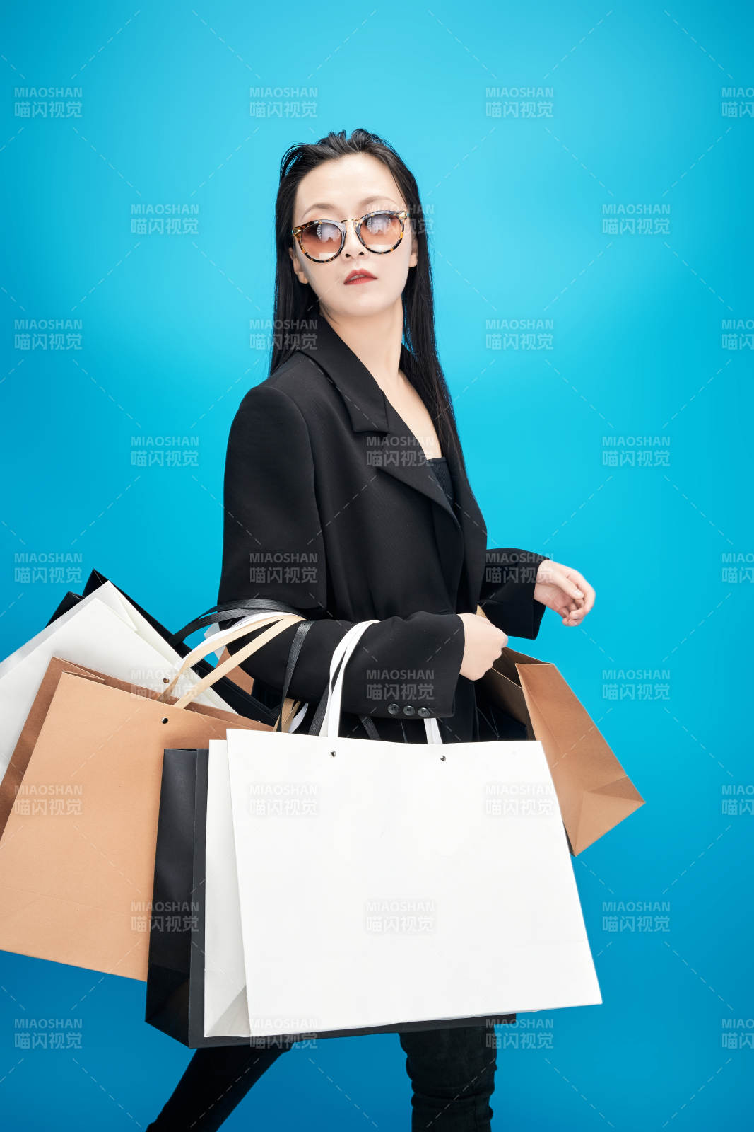 青藍色背景下手提購物袋的亞洲時尚少女