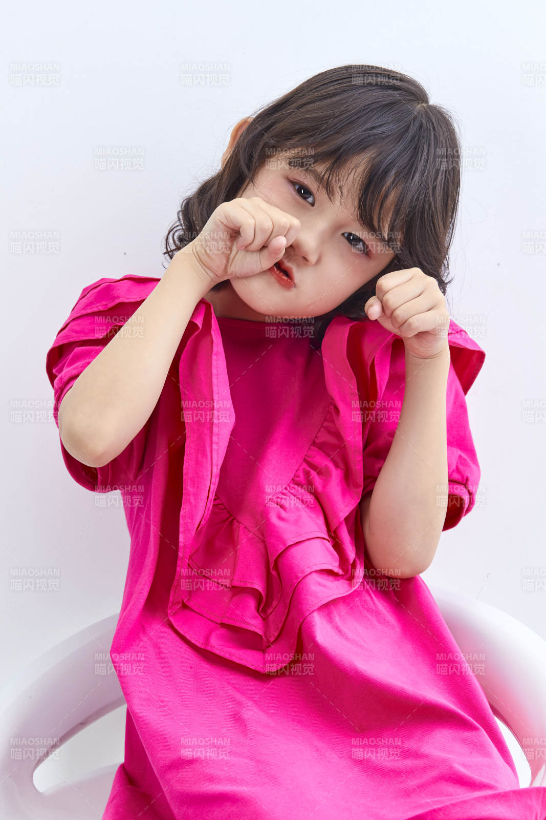 白色背景里坐在凳子上的可愛的亞洲小女孩兒童