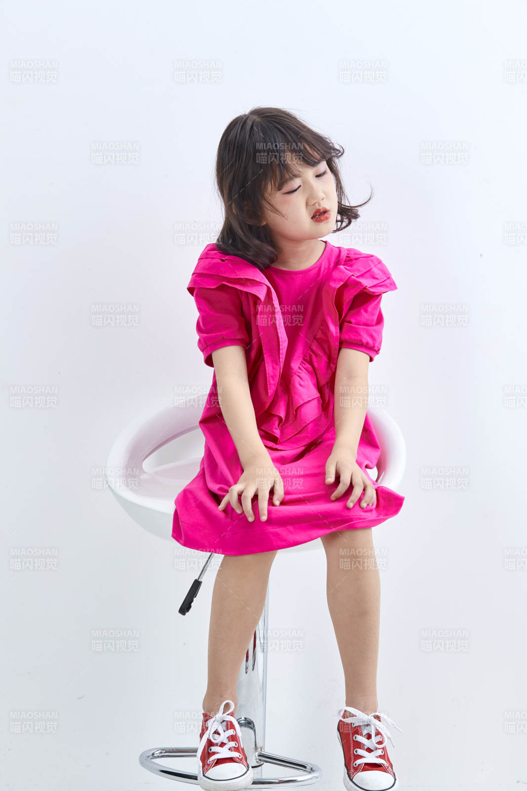 白色背景里坐在凳子上的可愛的亞洲小女孩兒童