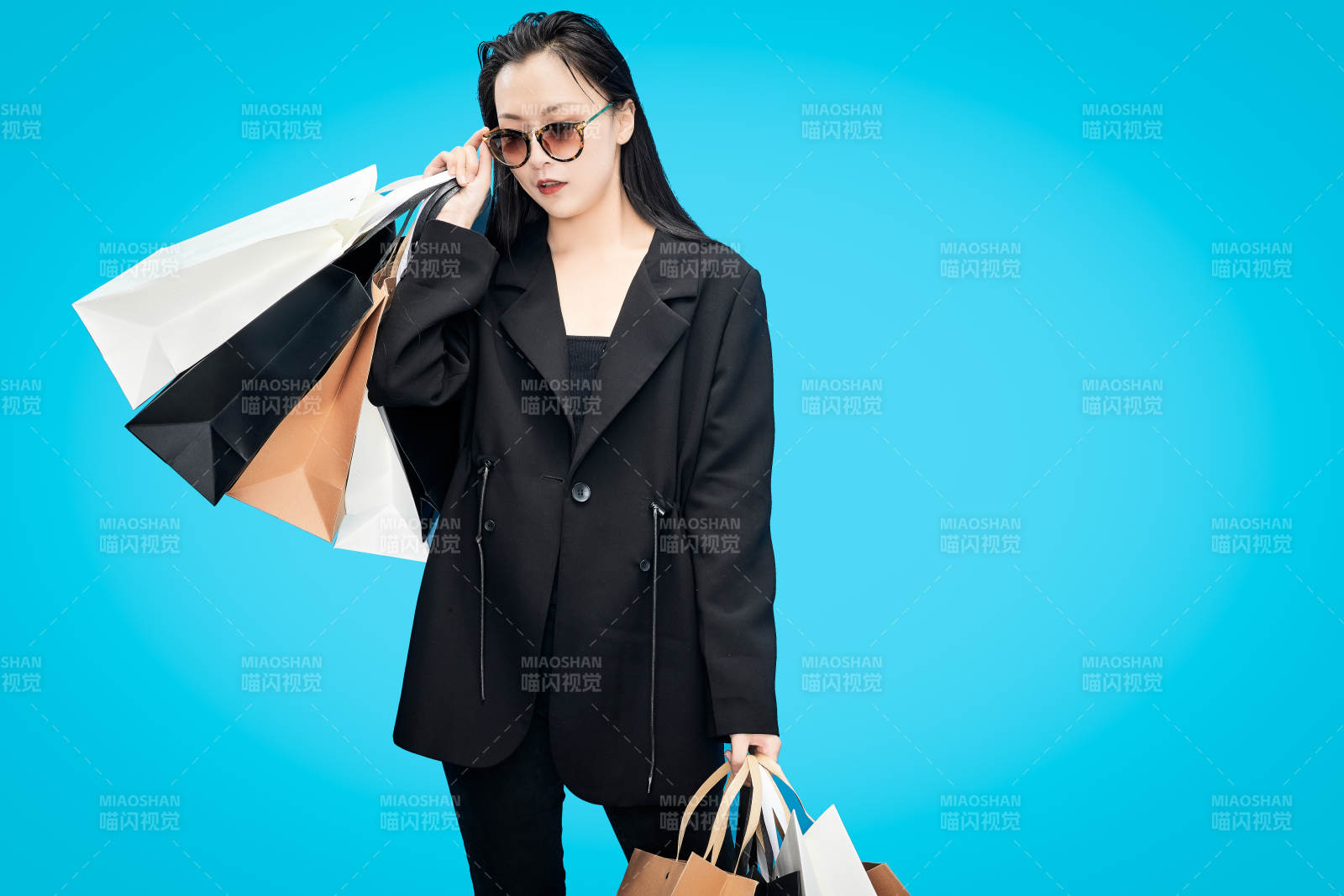 青藍色背景下手提購物袋的亞洲時尚少女