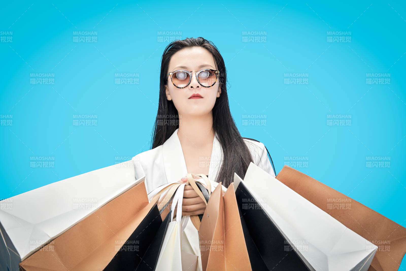 青藍(lán)色背景下手提購物袋的亞洲時(shí)尚少女