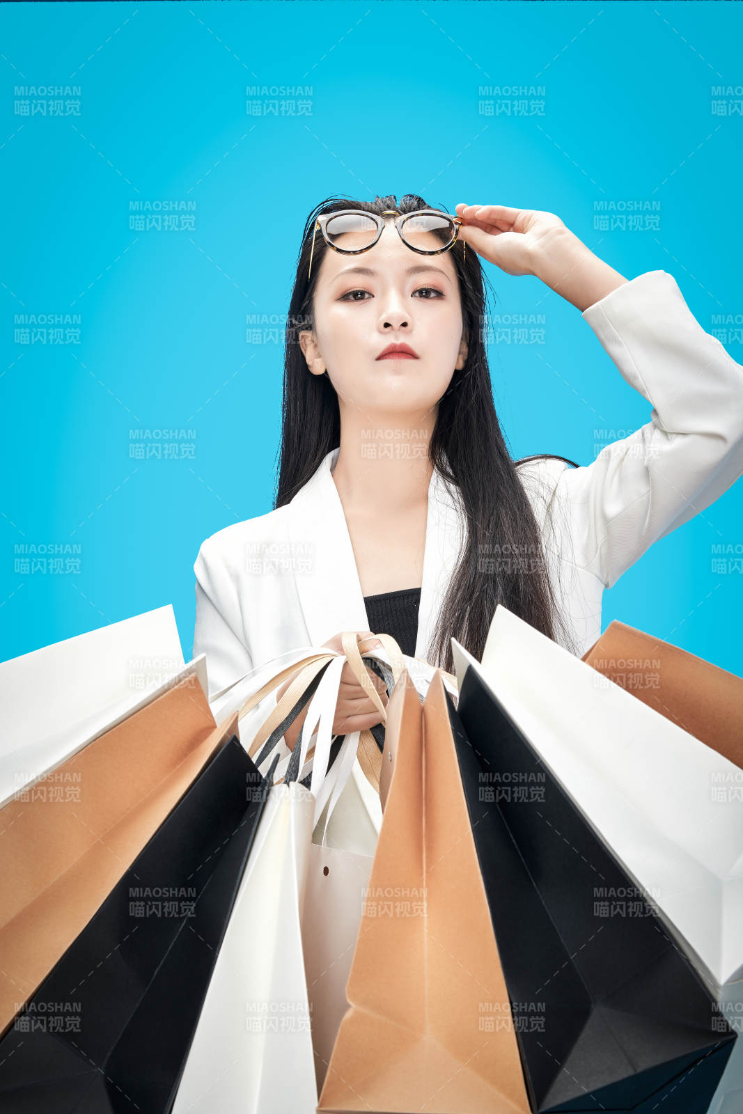 青藍色背景下手提購物袋的亞洲時尚少女