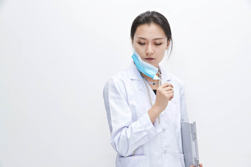 白色背景下手持病历夹的巡查医生人像