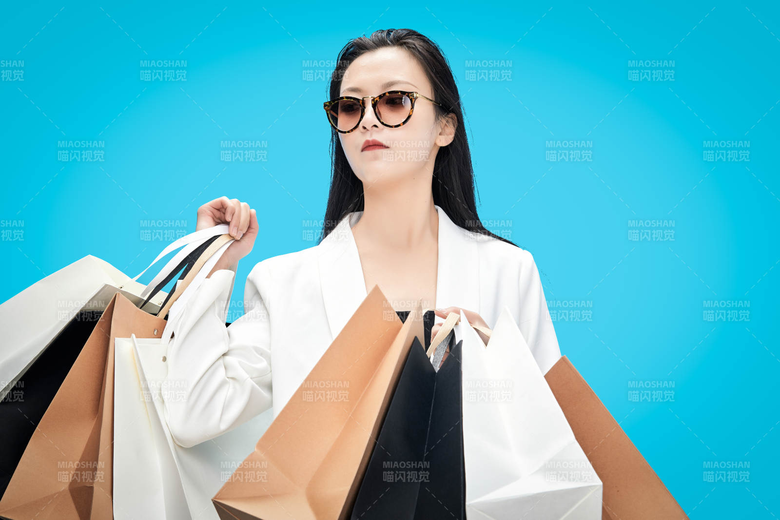 青藍色背景下手提購物袋的亞洲時尚少女