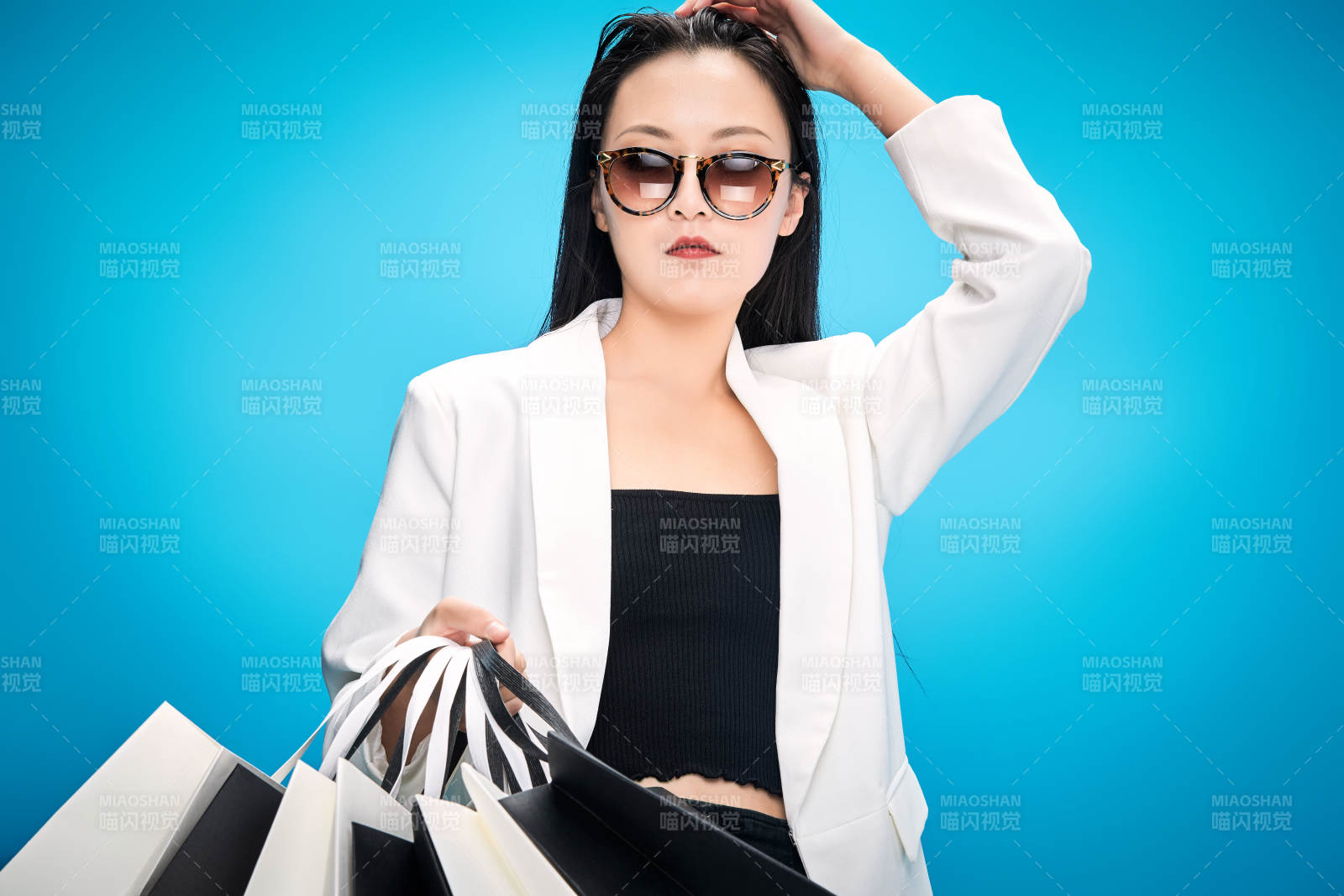 青藍色背景下手提購物袋的亞洲時尚少女