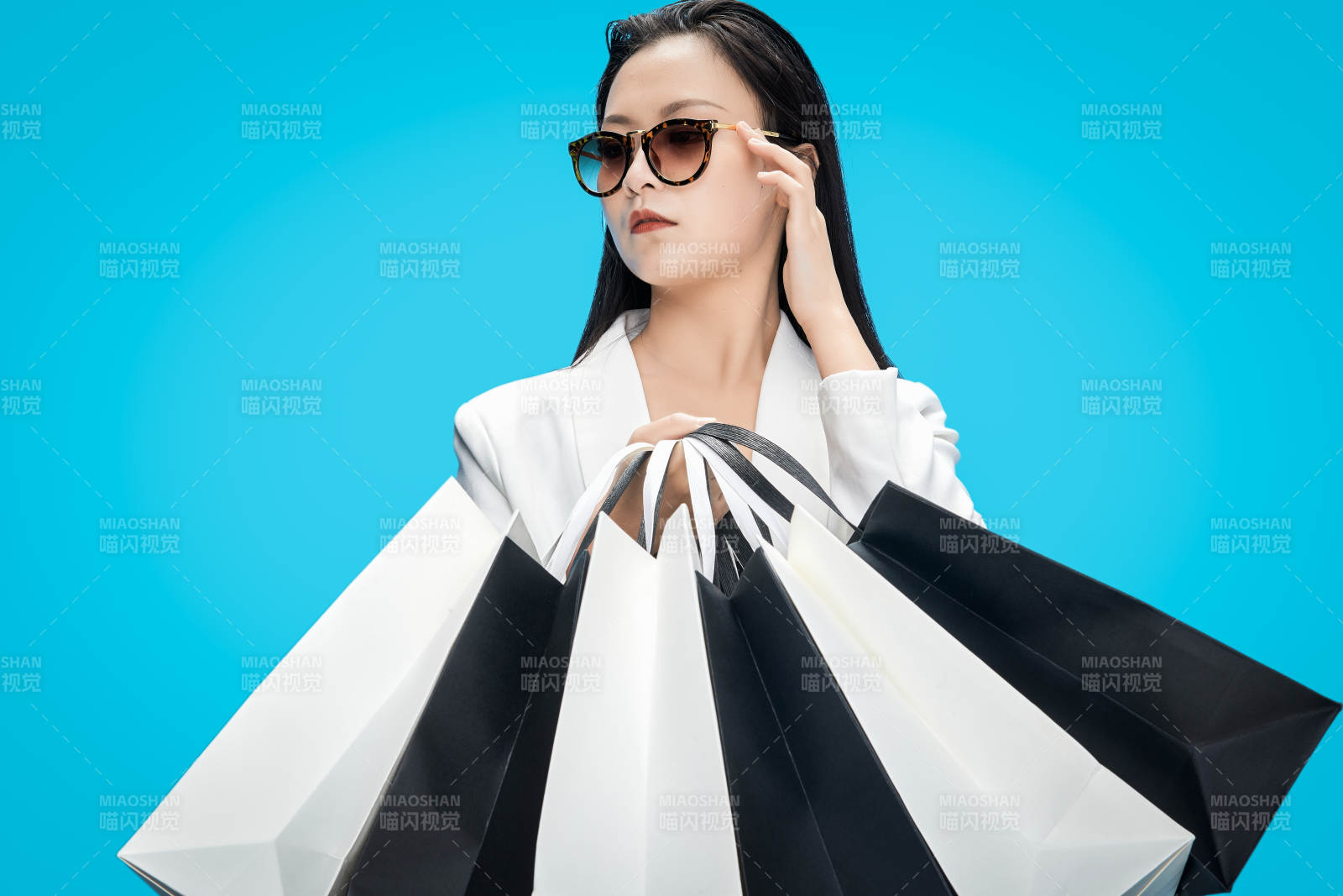 青藍色背景下手提購物袋的亞洲時尚少女