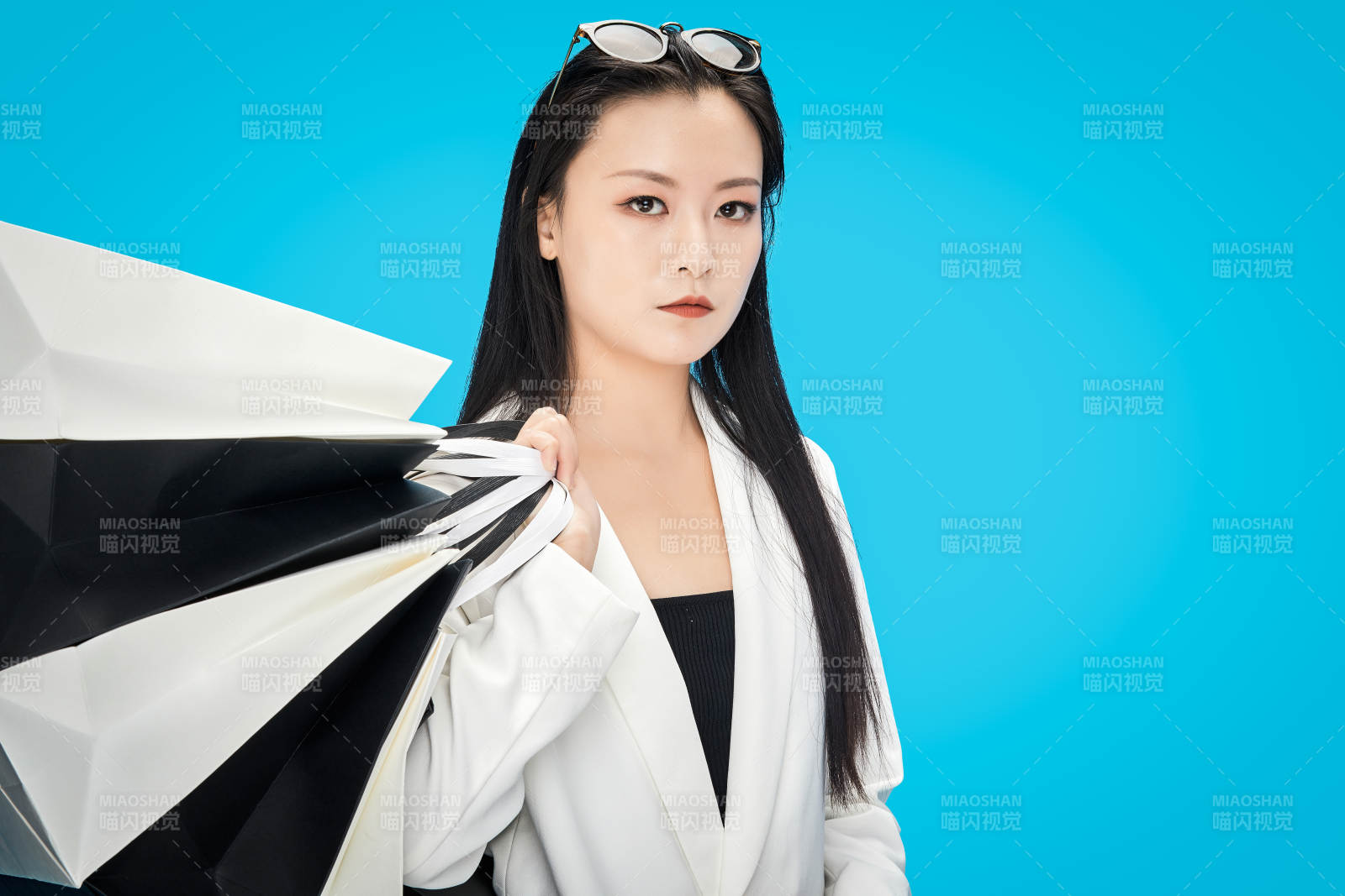 青藍(lán)色背景下手提購物袋的亞洲時(shí)尚少女