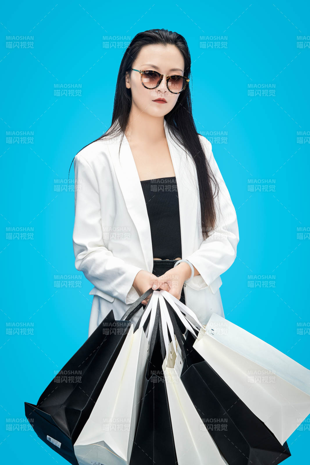 青藍(lán)色背景下手提購(gòu)物袋的亞洲時(shí)尚少女