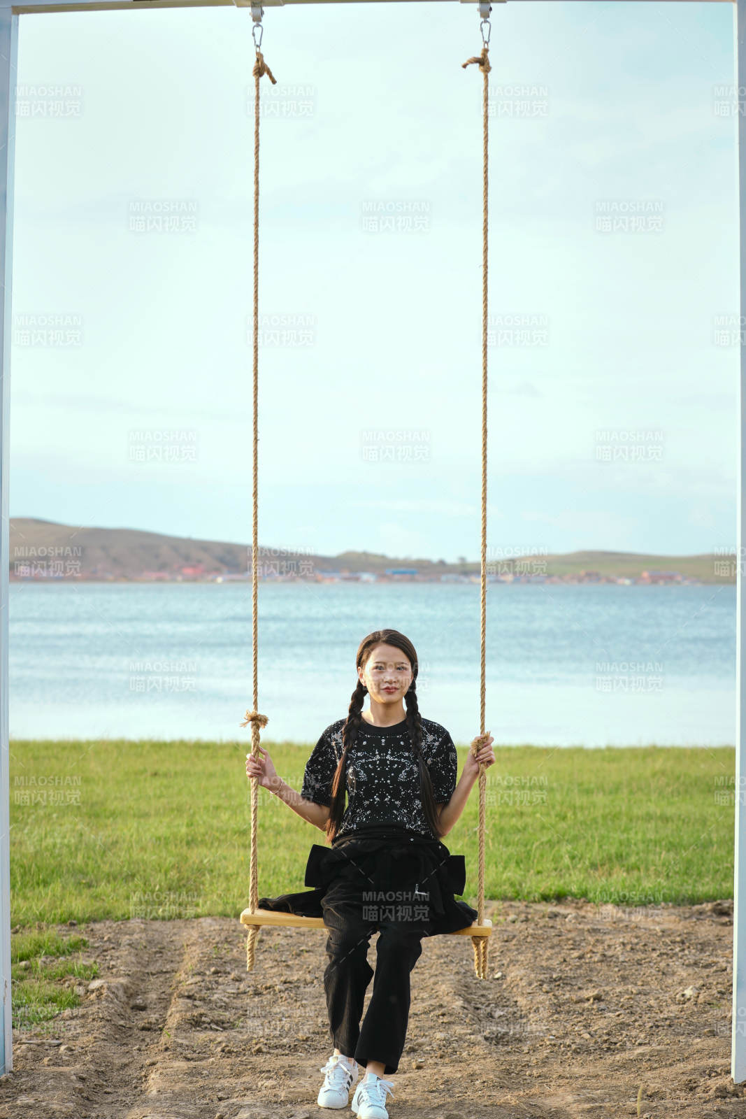 草原湖畔夕陽下蕩秋千的亞洲少女