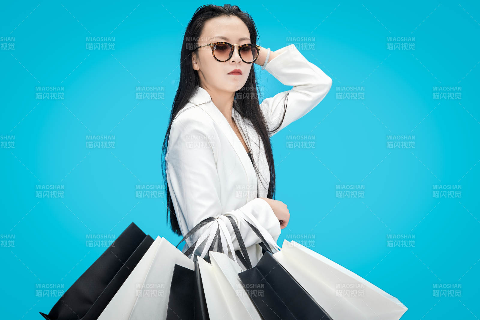 青藍色背景下手提購物袋的亞洲時尚少女