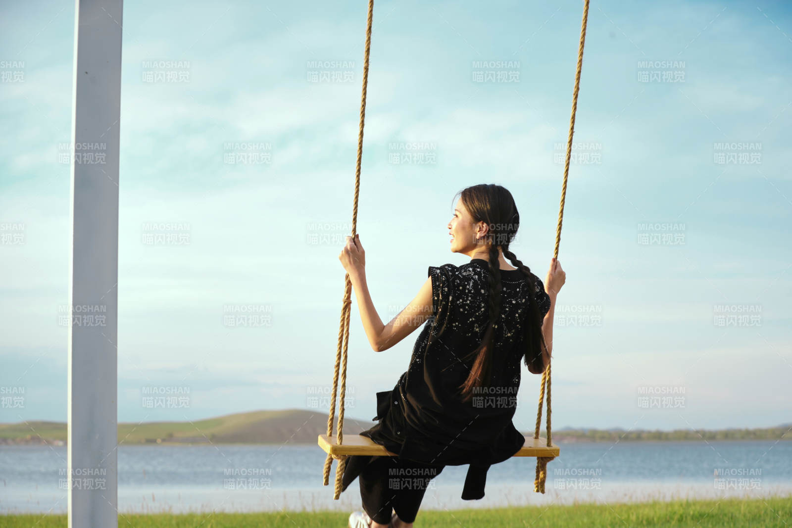 草原湖畔夕陽下蕩秋千的亞洲少女