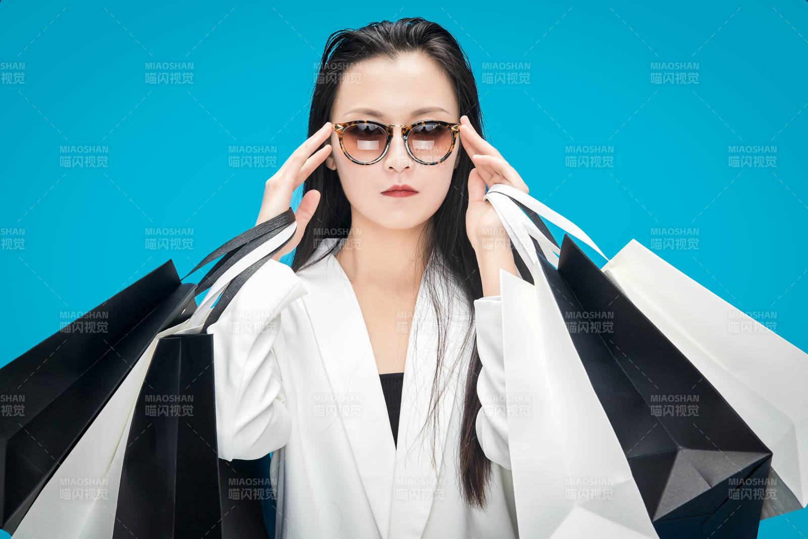 青藍色背景下手提購物袋的亞洲時尚少女