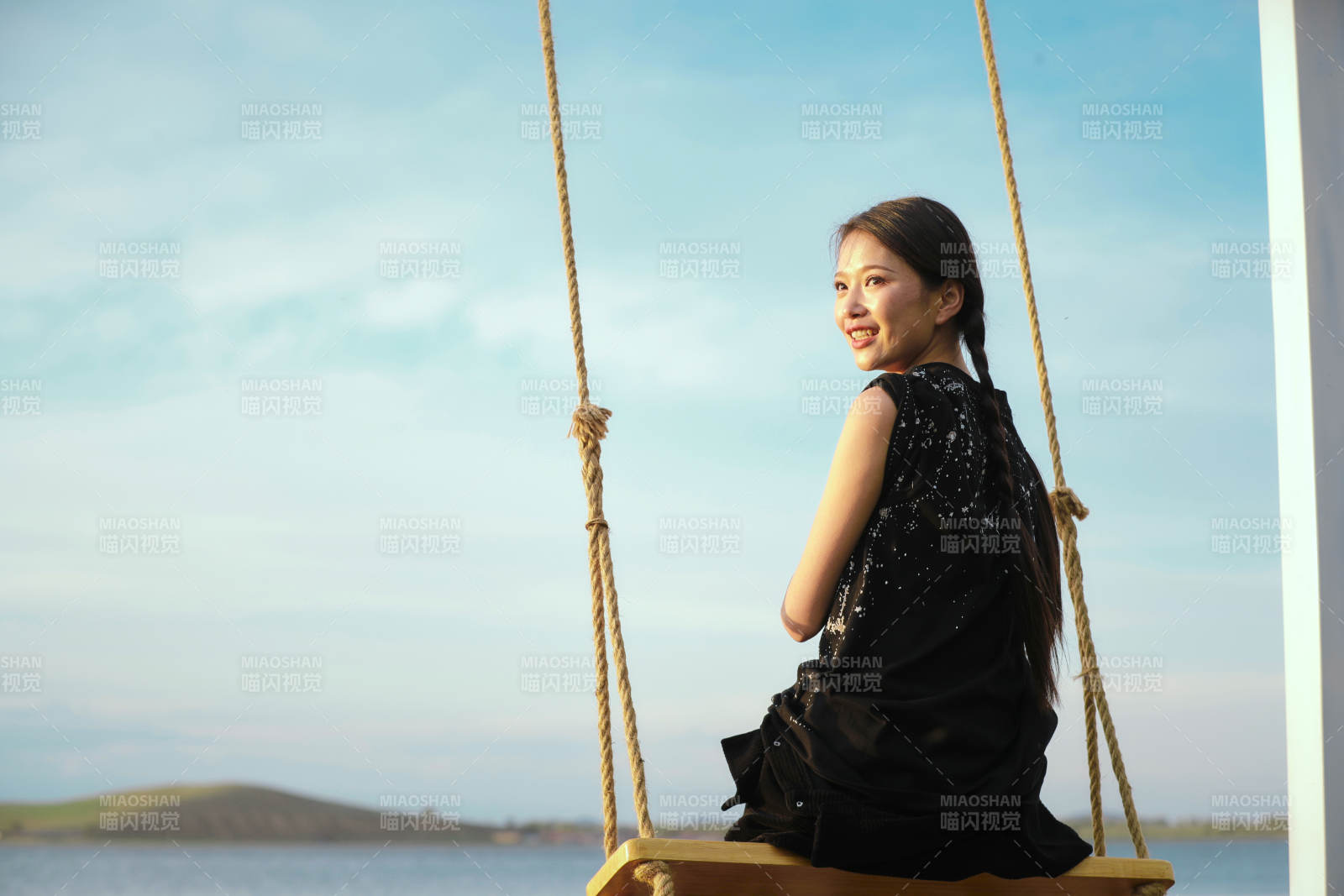 草原湖畔夕陽(yáng)下蕩秋千的亞洲少女