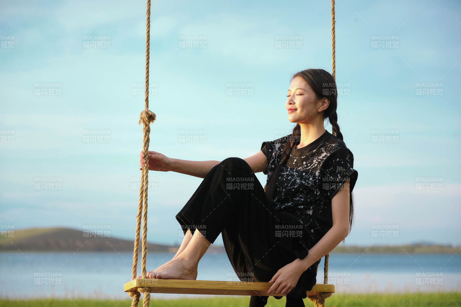 草原湖畔夕陽下蕩秋千的亞洲少女