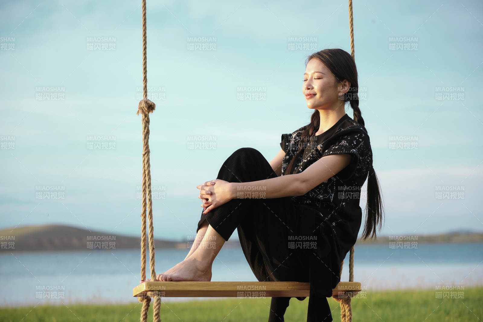 草原湖畔夕陽下蕩秋千的亞洲少女