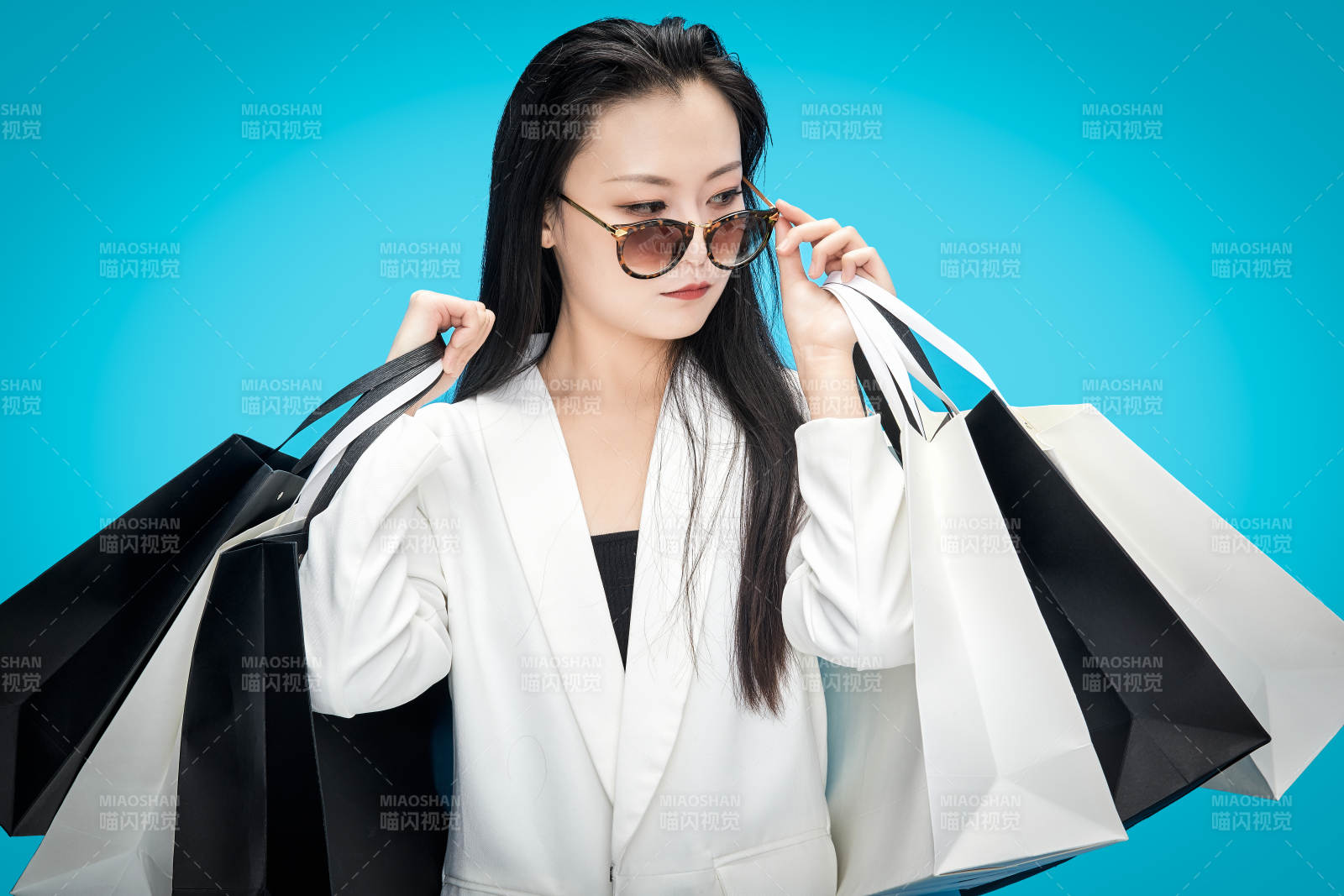 青藍色背景下手提購物袋的亞洲時尚少女