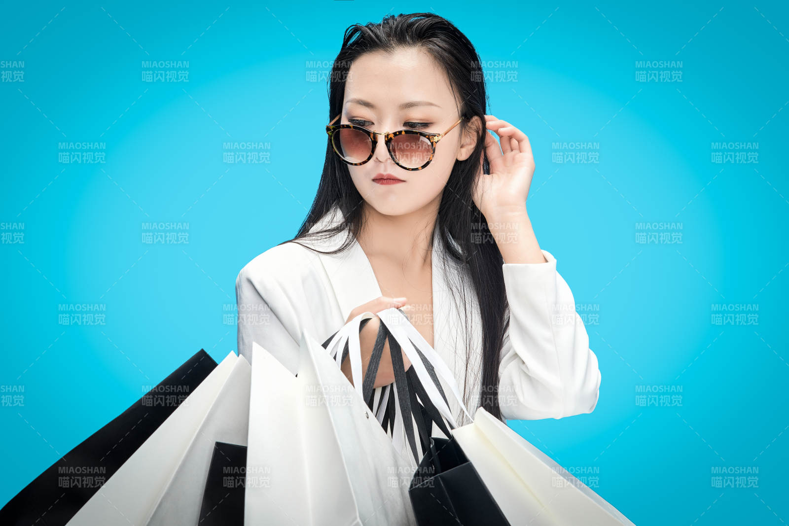 青藍(lán)色背景下手提購(gòu)物袋的亞洲時(shí)尚少女