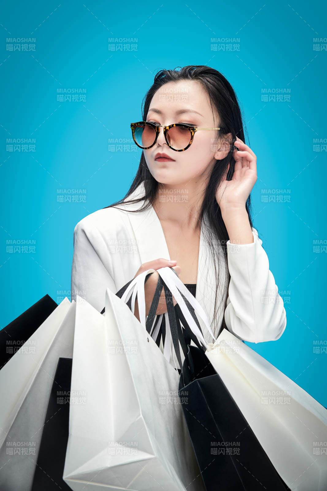 青藍色背景下手提購物袋的亞洲時尚少女