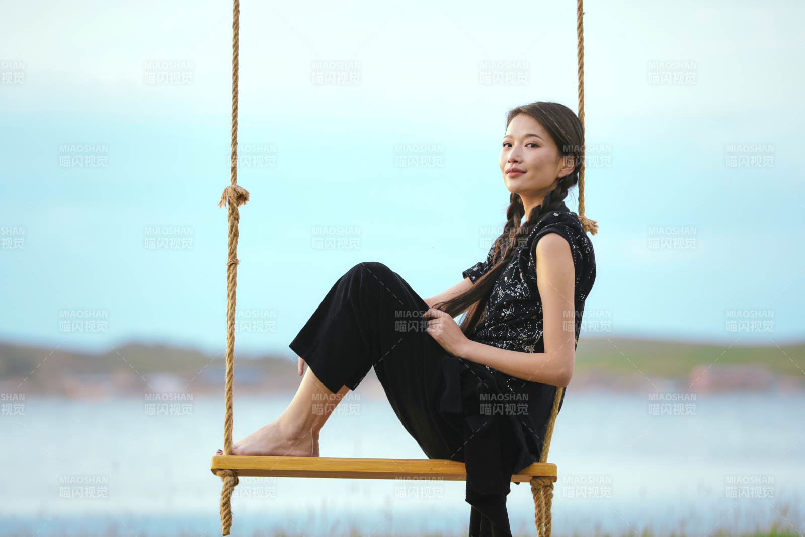 草原湖畔夕阳下荡秋千的亚洲少女