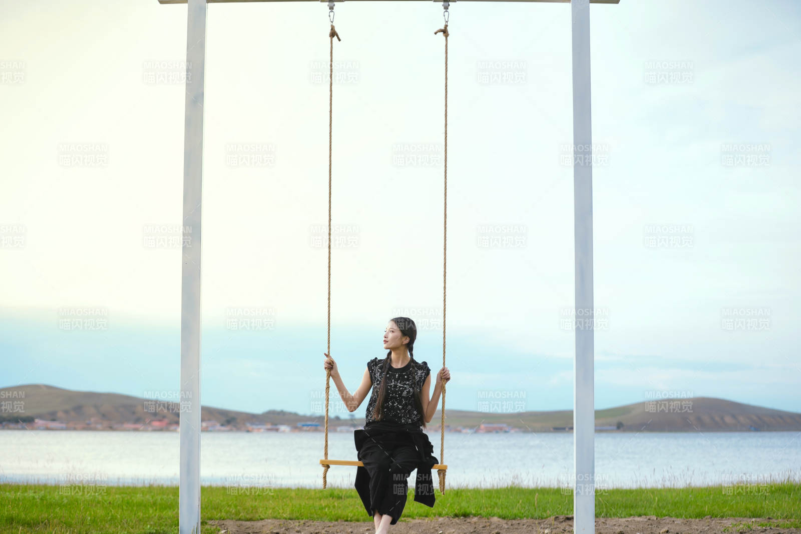 草原湖畔夕陽下蕩秋千的亞洲少女