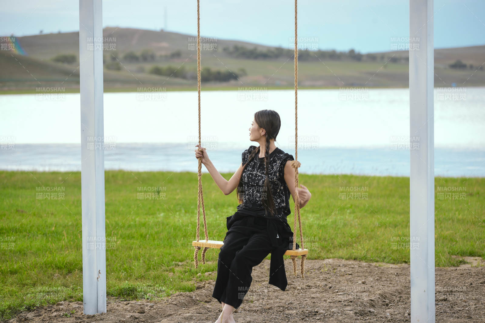 草原湖畔夕陽(yáng)下蕩秋千的亞洲少女